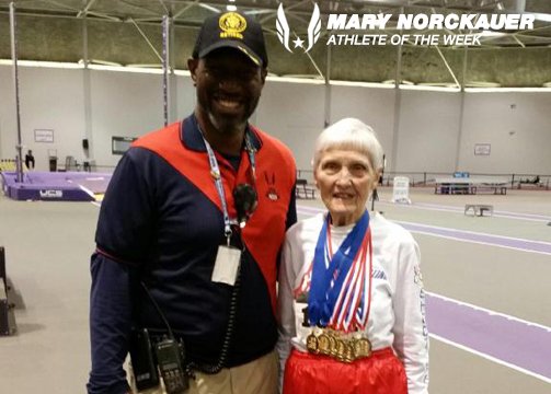 Mary posed with her medals and a meet official.