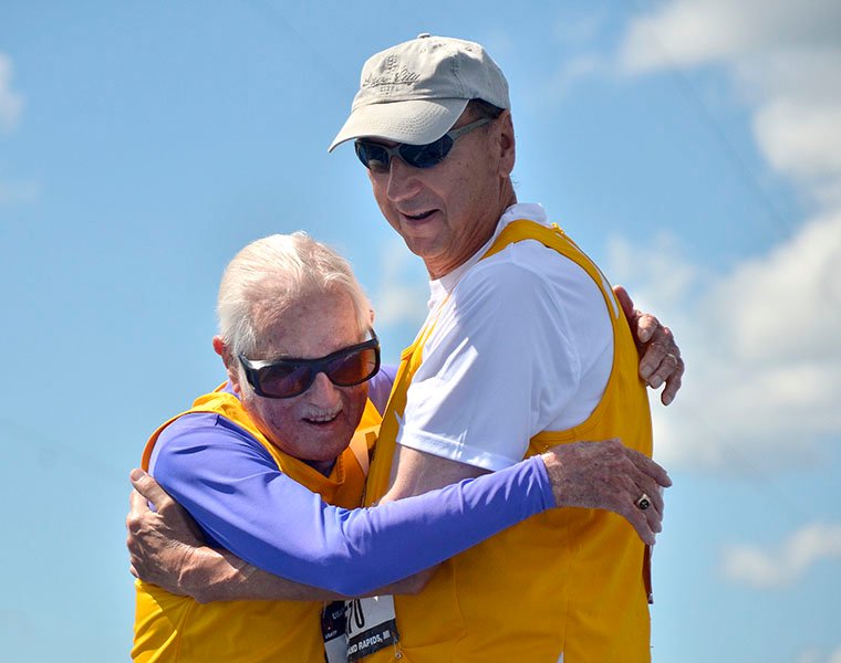 Champion Goldy and David RRRR embrace at finish of 100-meter dash.