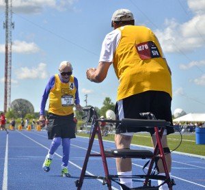 Champion heads for finish of 100 and arms of a teammate.