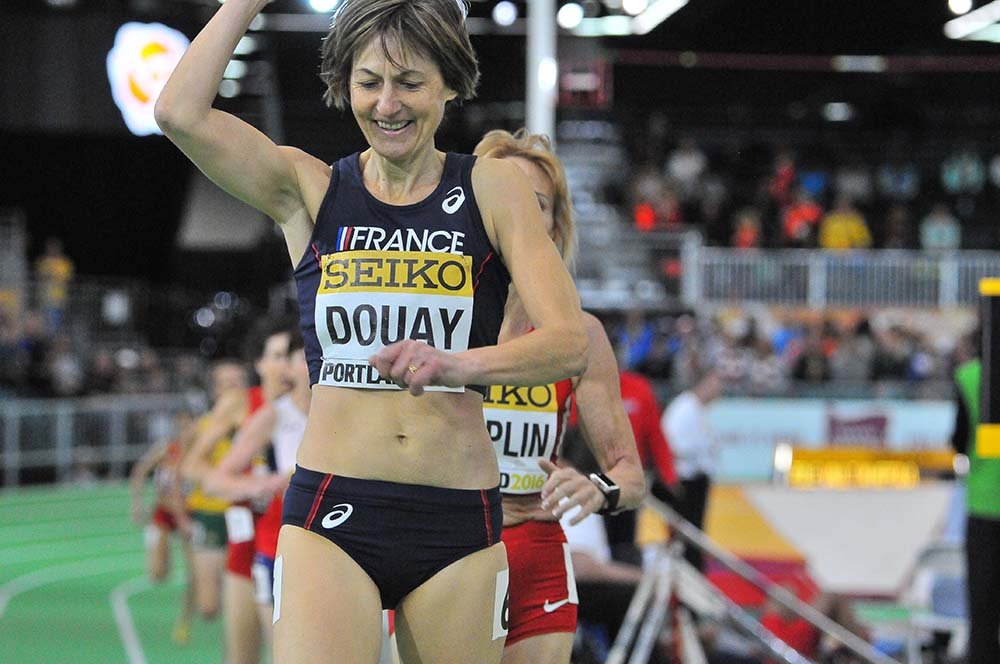 Helene Marie Douay of France celebrates winning the W55 race in 2:37.30,